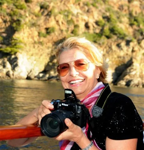 Francine Brochot, appareil photo en main, à bord d'un bateau